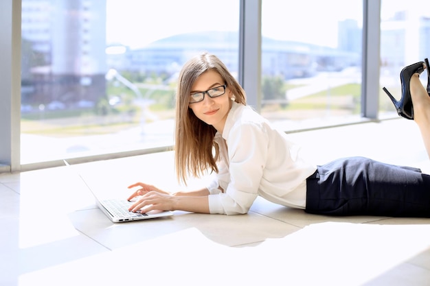 Nowoczesna Kobieta Biznesu Pracująca Z Laptopem Leżąc Na Podłodze W Przestrzeni Biurowej