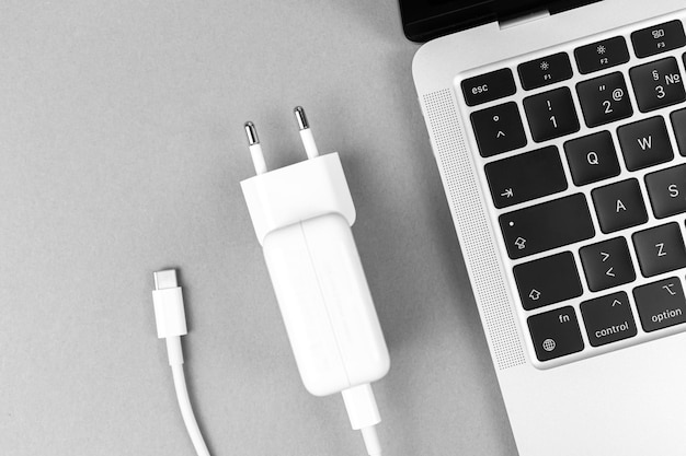 Nowoczesna ładowarka Usb Typu C Do Laptopa. Koncepcja Niskiego Poziomu Naładowania Baterii, Tło Technologiczne, Zdjęcie Z Widokiem Na Stół Biurowy