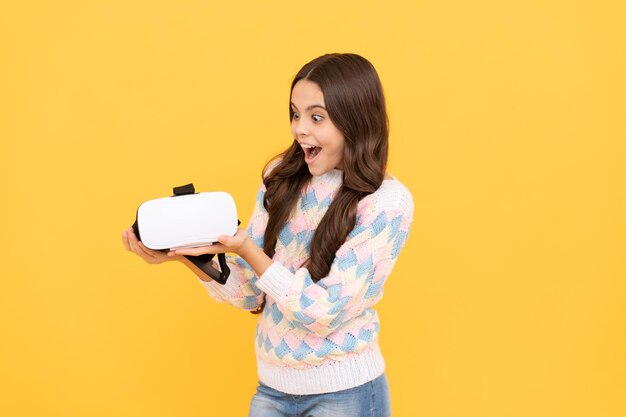 Nowoczesna technologia bezprzewodowa. rozwój dzieciństwa. zdziwiona dziewczyna trzyma bezprzewodowe okulary VR. za pomocą gogli VR. dzieciak grać w gry wideo. Cyfrowa przyszłość i innowacje. dziecko z goglami wirtualnej rzeczywistości.