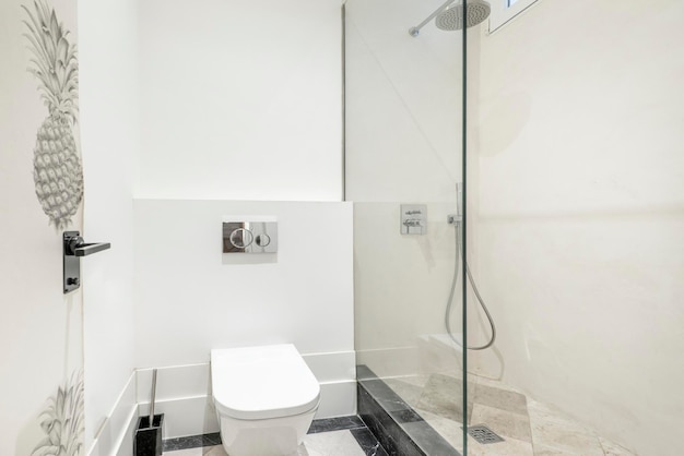 Nowoczesna toaleta z czarno-białymi marmurowymi podłogami i kabiną prysznicową ze szklaną przegrodą