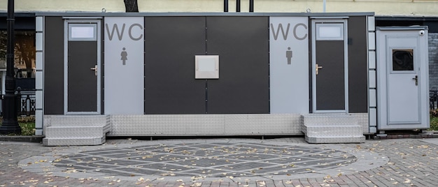 Nowoczesna toaleta zewnętrzna nowoczesna toaleta publiczna zewnętrzna zewnętrzna nowoczesna toaleta metalowa budynek zewnętrzny czas dzienny Fasada toalety zewnętrznej z mężczyznami kobiety znak WC
