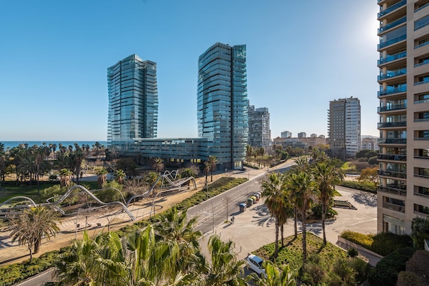 Nowoczesne budynki i słoneczny park w strefie przybrzeżnej z widokiem na morze w dzielnicy Diagonal Mar w Barcelonie