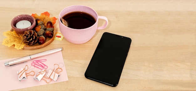 Nowoczesne kreatywne tło filiżanki herbaty, smartfona i liści