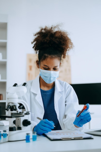 Nowoczesne laboratorium badań medycznych Afrykańska naukowiecka pracująca z mikro pipetami analizując próbki biochemiczne zaawansowane laboratorium chemiczne nauki dla medycyny xA