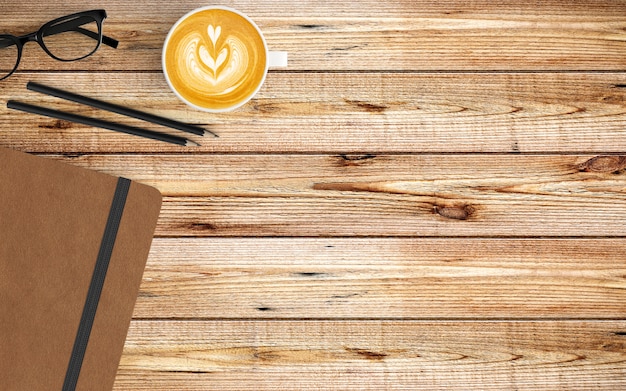 Zdjęcie nowoczesne miejsce do pracy z filiżanką kawy, notatnikiem i klawiaturą na drewnie