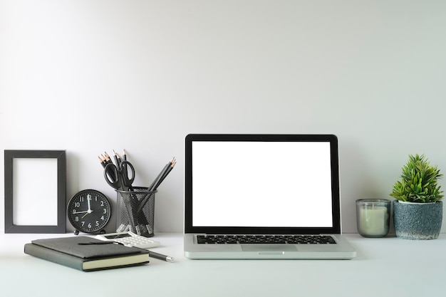 Nowoczesne miejsce pracy z rośliną doniczkową laptopa i ramką na obraz na białym stole Pusty ekran na tekst reklamowy