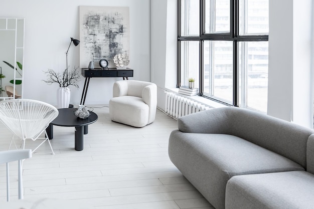 Nowoczesne, minimalistyczne wnętrze jasnego, jasnego monochromatycznego pokoju z czarno-białymi meblami, czyste białe ściany i ogromne okna