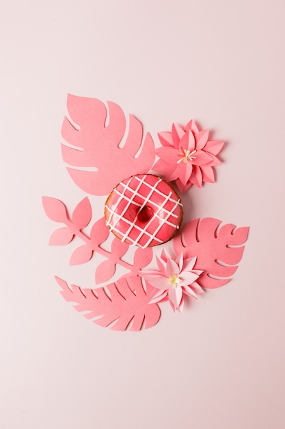 Nowoczesne pojęcie ciasta - różowe przeszklone pączki i origami papercraft kwiaty i rośliny na różowo