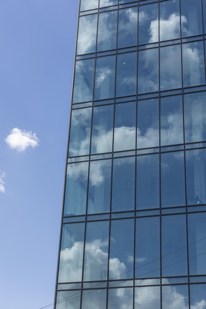 Nowoczesny biurowiec ze szklaną fasadą na czystym tle nieba Przezroczysta szklana ściana biurowca