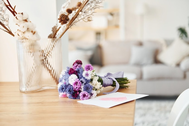 Nowoczesny domowy pokój z łóżkiem Kwiaty na stole Szczęśliwego dnia matki