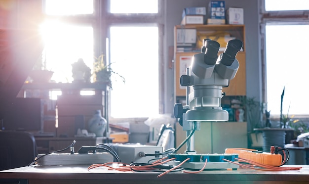 Nowoczesny mikroskop, element złączy i duży zielony mikroukład w laboratorium warsztatowym