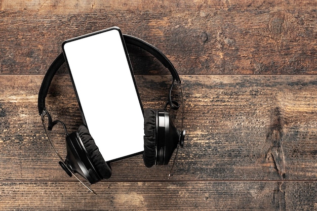 Nowoczesny telefon komórkowy z pustym białym ekranem do wstawiania napisu lub logo ze słuchawkami bezprzewodowymi na białym tle puste dla przestrzeni kopii projektu lub makiety