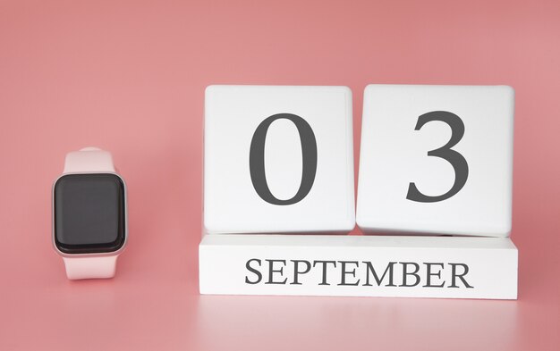 Nowoczesny zegarek z kostkowym kalendarzem i datą 03 września na różowej ścianie. Koncepcja wakacje w czasie jesieni.