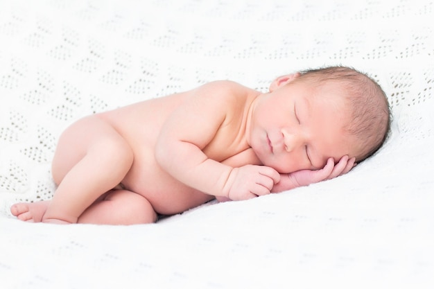 Noworodek śpi i uśmiecha się. bliska portret pięknego śpiącego dziecka