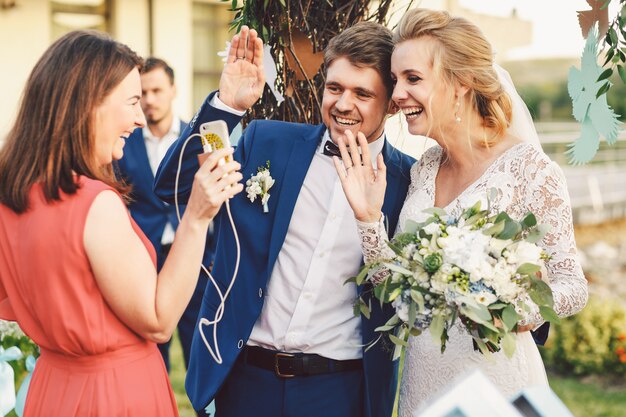 Zdjęcie nowożeńcy machają rękami do kogoś przez telefon