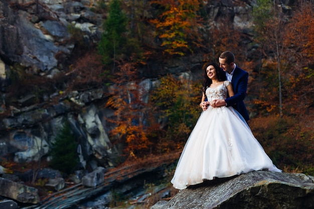 Nowożeńcy na dużym kamieniu bez tła skał i jesieni