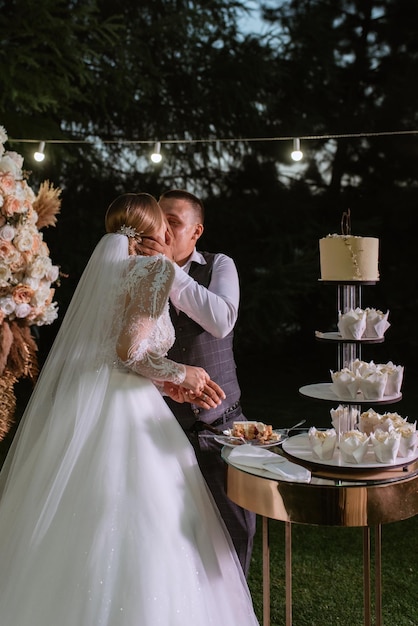 Nowożeńcy radośnie kroją i smakują tort weselny