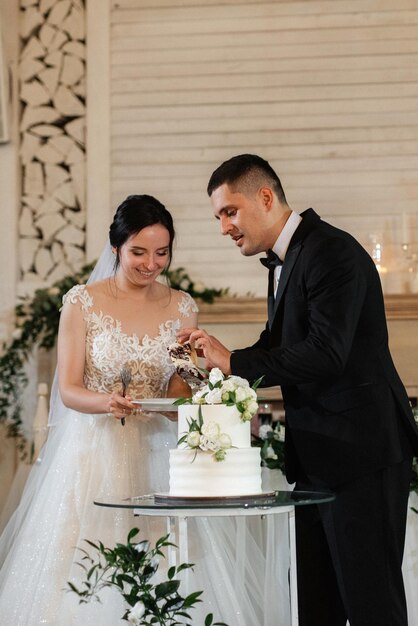 Nowożeńcy radośnie śmieją się i smakują weselny tort