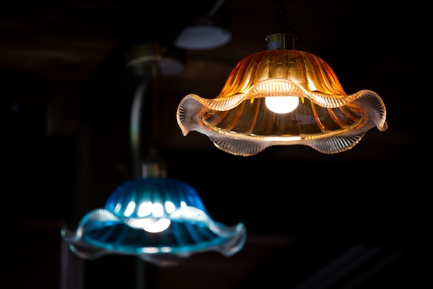 Nowożytna wisząca lampa z nieociosanym drewnianym wewnętrznym domu wiejskiego tłem.