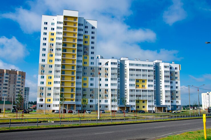 Nowy blok nowoczesnych apartamentów z balkonami i błękitnym niebem w tle