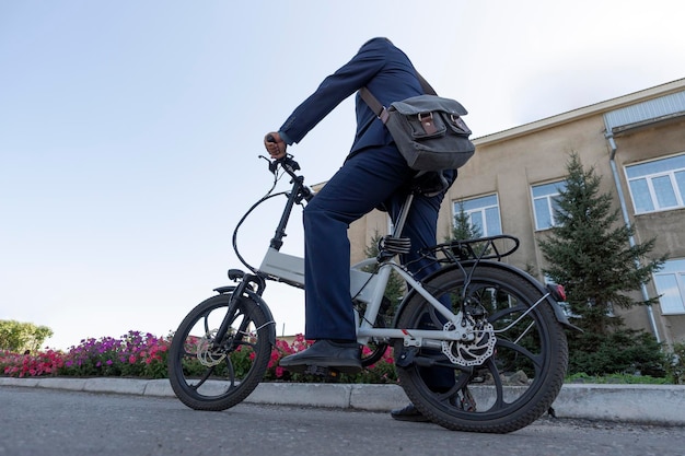 Nowy nowoczesny alternatywny środek transportu Ekologiczny rower elektryczny Hipster biznesmen dojeżdżający do pracy z rowerem elektrycznym podróżujący do pracy w mieście