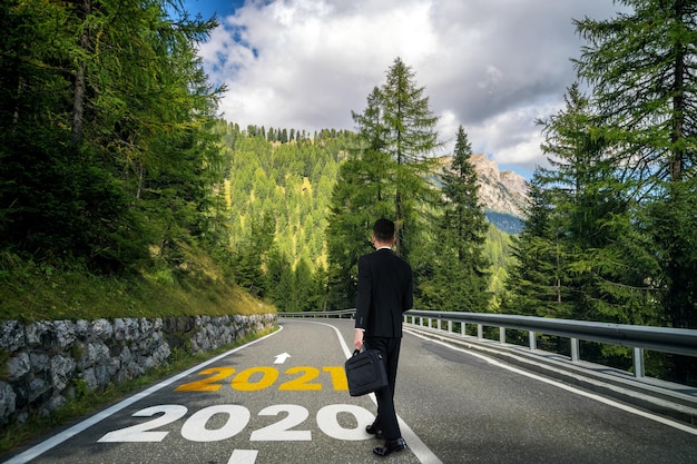 Nowy Rok 2021 i koncepcja wizji przyszłości. Biznesmen podróżujący autostradą prowadzącą do obchodów szczęśliwego nowego roku na początku 2021 r. na świeży i udany początek.