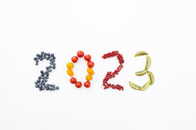 Zdjęcie nowy rok 2023 z owoców na białym tle zdrowa żywność