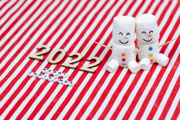 Zdjęcie nowy rok i wesołych świąt 2022. para bałwanów marshmallows. motyw nowego roku.
