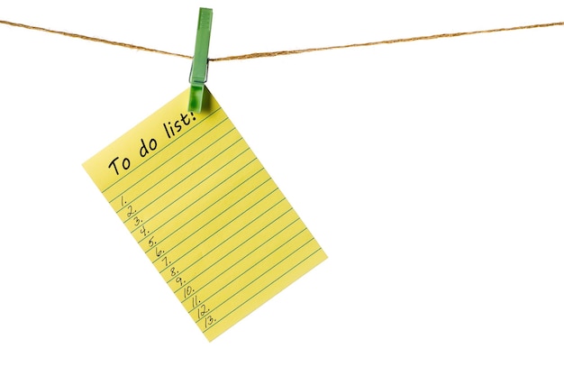 Nowy rok nowe cele żółty papier samoprzylepny na sznurku na białym tle na liście do zrobienia