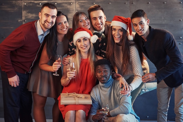 Nowy Rok się zbliża! Grupa rozochoceni młodzi wieloetniczni ludzie w Santa kapeluszach na przyjęciu, pozuje emocjonalnego stylu życia pojęcia ludzi