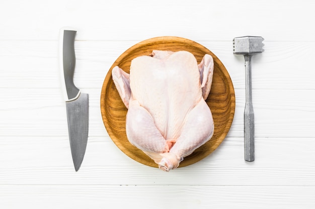 Zdjęcie nóż i młotek do steków w pobliżu kurczaka