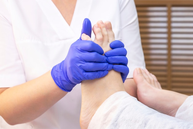 Nożny masaż w zdroju salonie, zbliżenie. masaż stóp rozluźnia pielęgnację skóry. Pedicure terapeutyczny.