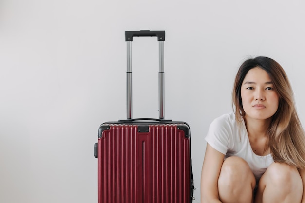 Nudzona i zmęczona kobieta w prywatnej odzieży i bagażu odizolowana na białym