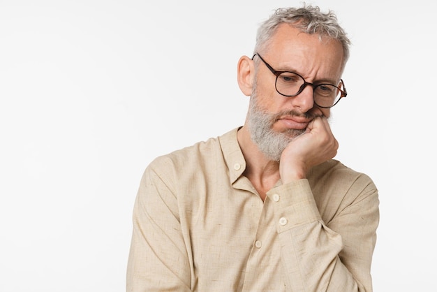 Nudzony zmęczony wyczerpany smutny biały dojrzały mężczyzna w średnim wieku nauczyciel freelancer noszący okulary chce spać czując negatywne emocje depresja izolowany na białym tle