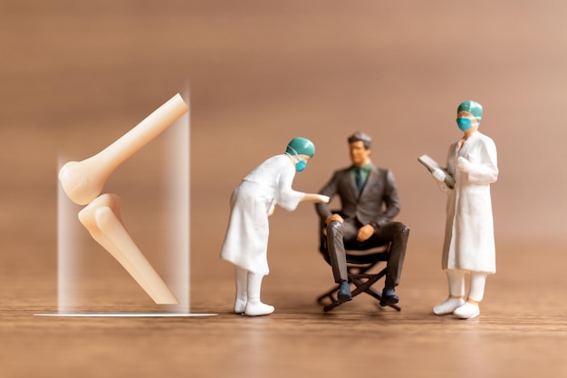 O pacjentach z miniaturowymi ludźmi rozmawia lekarz ortopeda