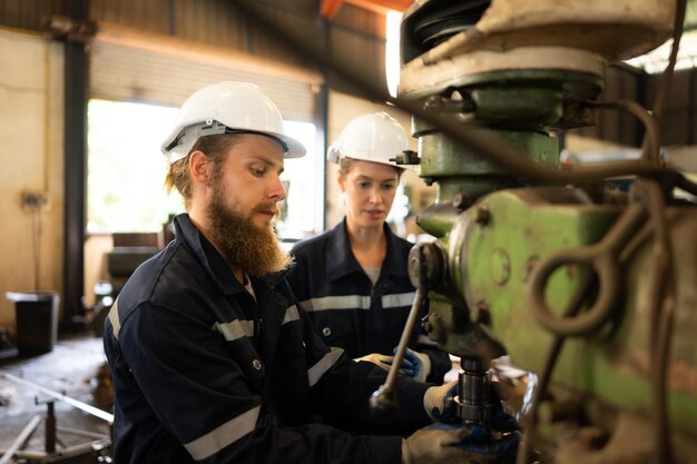 Zdjęcie obaj inżynierowie mechaniczni sprawdzają stan pracy starej maszyny