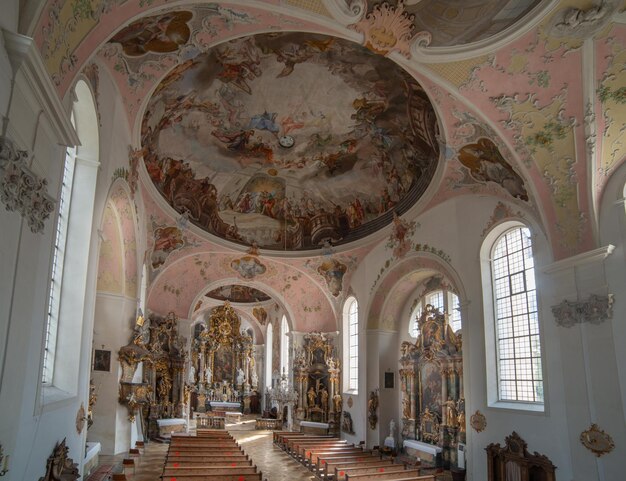 Oberammergau Niemcy 31 lipca 2019 Architektura wnętrz z dekoracjami meblowymi freskami i rzeźbami kościoła parafii katolickiej Pawła i św Piotra w Oberammergau