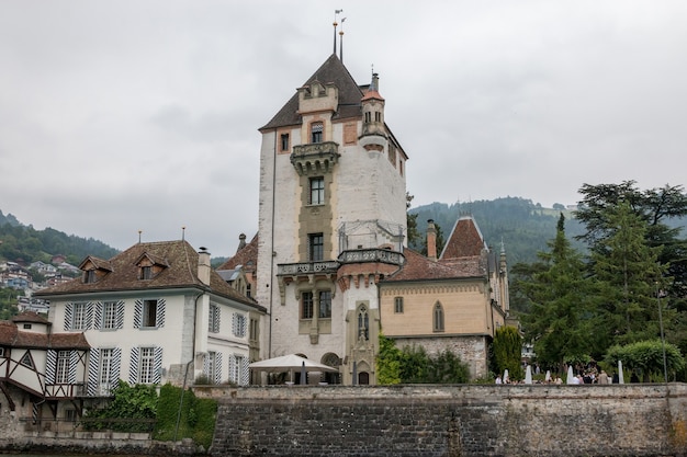 Oberhofen, Szwajcaria - 24 czerwca 2017 r.: Widok na zamek Oberhofen - żywe muzeum i park ze statku, Szwajcaria, Europa. Letni krajobraz, słoneczna pogoda, błękitne niebo i słoneczny dzień