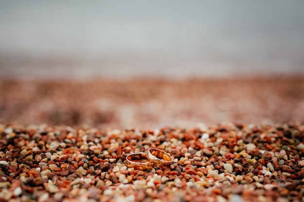 Obrączki nowożeńców na kamykach plaży