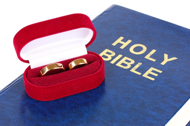Obrączki ślubne na Biblii na białym tle