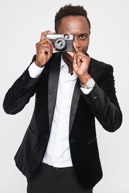 Obraz atrakcyjny młody biznesmen Afryki zrobić zdjęcie aparatem. Pojedynczo na białym tle.
