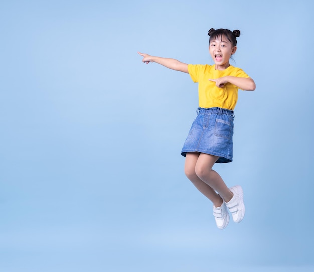 Obraz Azjatyckiego Dziecka Pozującego Na Niebieskim Tle