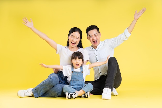 Obraz Azjatyckiej Rodziny Siedzącej Razem Szczęśliwej I Odizolowanej Na żółtym Tle