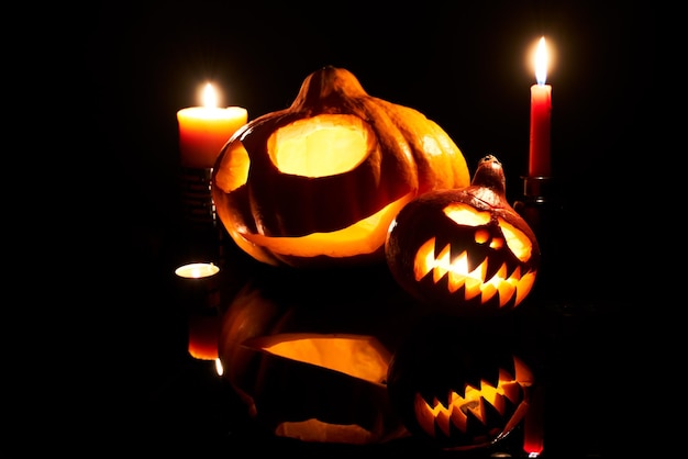 Obraz halloweenowych dyni z płonącymi ustami świec na pustym czarnym tle