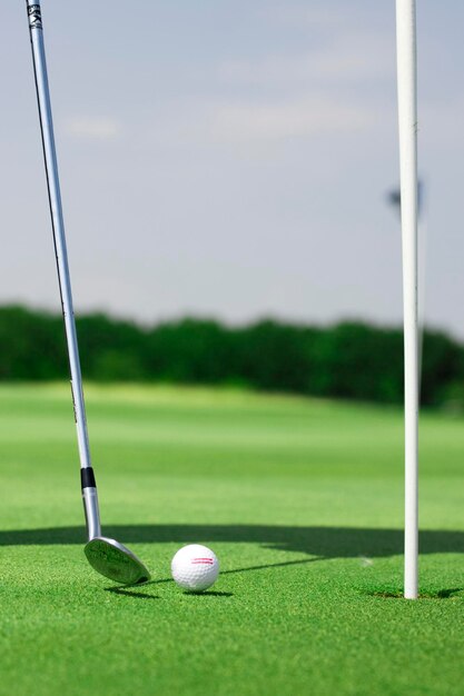 Obraz krajobrazu golfowego z piłką golfową i kijem