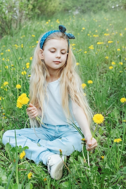 Obraz ładnej Małej Dziewczynki Siedzącej Na Polu Mniszka Lekarskiego