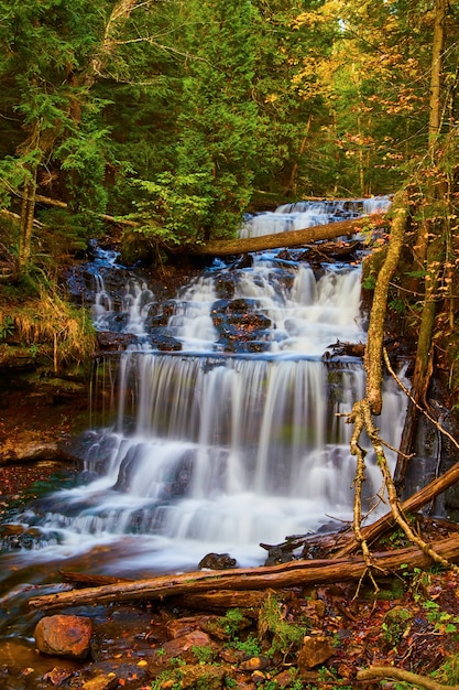 Obraz malowniczych wodospadów spływających kaskadami w dół wielu poziomów w jesiennym lesie