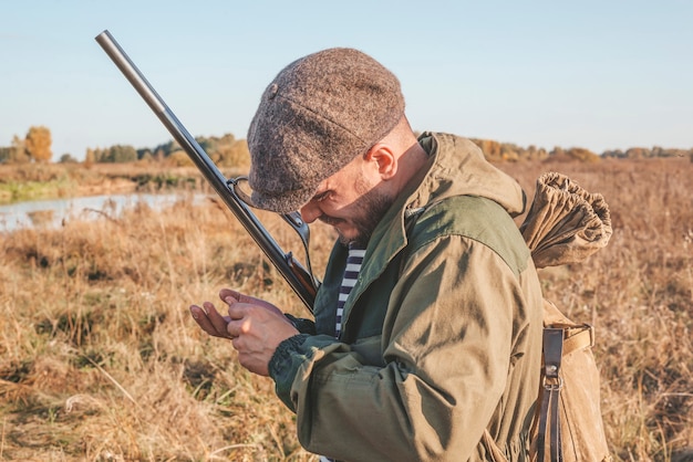 Obraz mężczyzny ze strzelbą podczas polowania. Sezon polowań na kaczki. Różne środki przekazu
