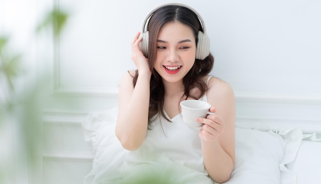 Obraz młodej Azjatki słuchającej muzyki rano w domu