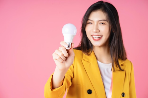 Obraz młodej azjatyckiej bizneswoman trzymającej żarówkę koncepcja burzy mózgów